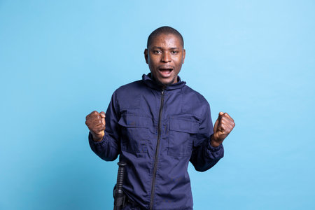 African american agent with uniform acting shocked in studio, having a surprised reaction after...