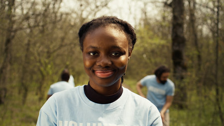 African american girl presenting small sprout with organic soil ready for planting in the ground, preserving nature and forest habitat. Young activist doing voluntary work to grow trees. Camera B.の写真素材