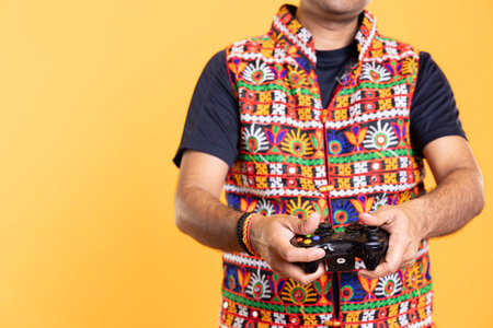 Close up shot of man wearing colorful vest playing videogames using controller, studio background. Gamer holding gamepad, participating in online multiplayer game using console systemの写真素材