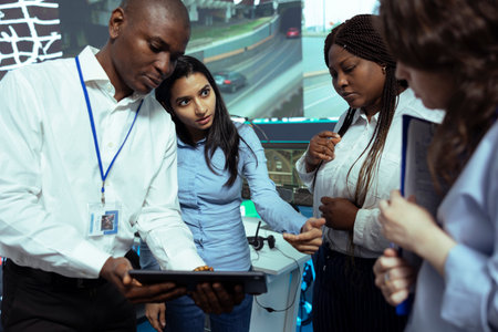 Team of diverse employees analyzing order logistics on awb papers, finding the shipment location and fixing the gps coordinates on satellite map. Group of operators work on express delivery.の写真素材