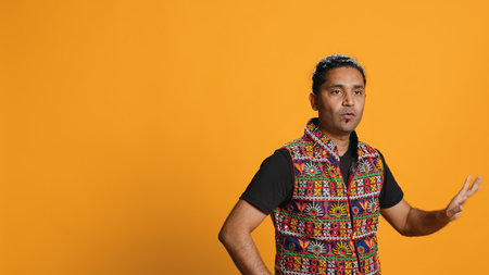 Happy indian person having fun, dancing on rhythm, enjoying leisure time. Cheerful man entertaining himself doing funky movements, isolated over studio background, camera Aの写真素材