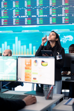 Team of forecast affiliates examining annual infographics on a big data screen, using workflow...