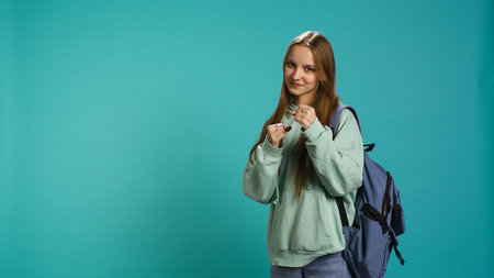 Woman doing fighting stance, pretending to do boxing, isolated over studio background. Young fighter throwing punches, doing athletic guard pose during combat practice, camera Bの写真素材