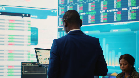 Administrative assistant examining important big data visualizations on a huge display, creating an...