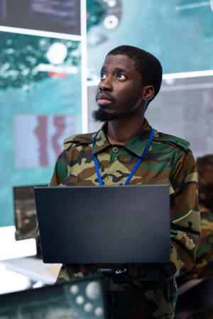 Army personnel coordinating special operations mission in control center, monitoring surveillance...