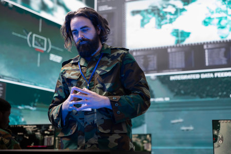 Army soldier reviewing information on a hologram projection in control center, creating a...