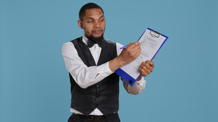 Hotel concierge showing the check in forms for registration at the five star resort, needs a...