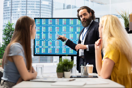 Broker showing stock exchange indices on screen in financial department office used for forecasting and analysis purposes. Agent working in company workspace with business figures on displayの写真素材