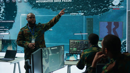 Military personnel operate advanced systems in a command center, focusing on surveillance and data...