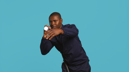 Portrait of security guard catching intruder with flashlight while overseeing premises. Private law enforcement worker calls over trespasser after detecting him with lantern, studio backdrop, camera Bの写真素材
