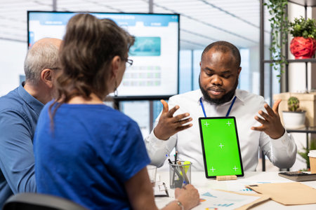 Consultant presents copy space display on tablet to senior clients in modern office, counseling meeting for retirement and pension plan. Financial adviser helps middle aged people with finances.の写真素材