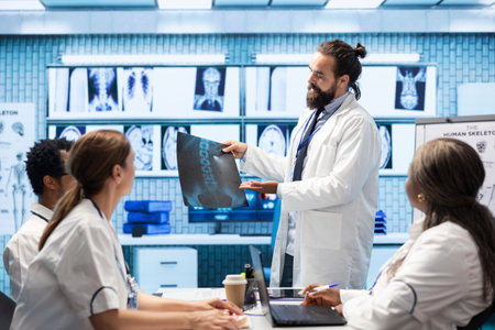 General practitioner gathering healthcare experts review x ray scans in a private clinic meeting. Licensed professionals focusing on diagnostics and disease prevention, collaborative teamwork.の写真素材