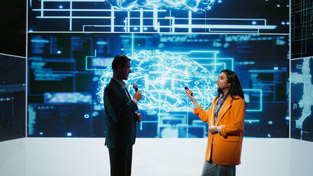 Presenter and guest chatting during AI summit discussion panel bringing together tech companies, exploring latest developments in artificial intelligence industry and emerging technologies, camera Bの写真素材
