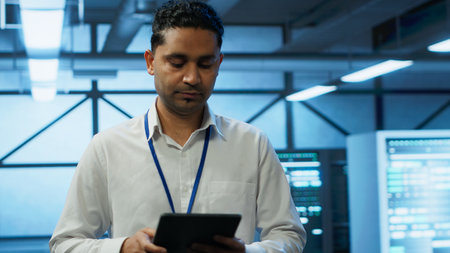 Programmer walking in high tech data center used for managing infrastructure energy consumption,...