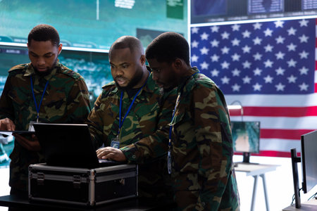 Military team operates high tech computers and a big screen in a command post, managing advanced surveillance systems, protecting national security and handling cybersecurity threats.の写真素材