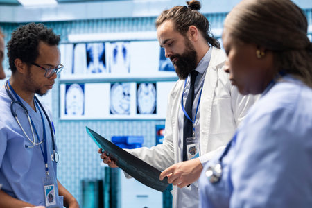 Radiologists and specialists examine x rays and discuss medical care in a private clinic. Team of skilled healthcare experts working together to provide accurate diagnosis and treatment options.の写真素材
