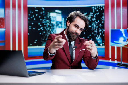 Broadcaster transmitting live information on television, reading headlines in news studio on global communications channel. Male news anchor reviewing daily events and covering all topics.の写真素材