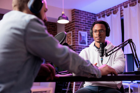 Podcast presenter having live discussion with man, streaming it for audience on internet...