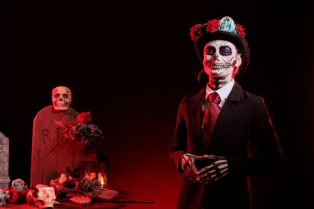 Portrait of smiling girl in graveyard at Dia de los Muertes indigenous rites of honoring the dead. Woman wearing formal suit participating in Day of the Dead celebration in honor of the deceasedの写真素材