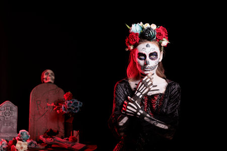 Person wearing skull makeup and horror costume to celebrate dios de los muertos during Halloween. Creepy woman dressed as La Catrina on day of the dead holiday, doing celebrationの写真素材