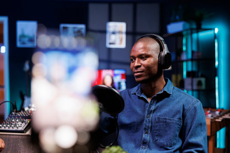 Close up shot of a blogger recording a vlog using a smartphone on a tripod. The content creator is using videography equipment to record for a podcast channel on social media.の写真素材