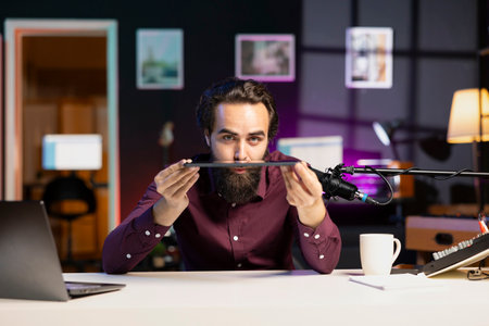 Influencer in home studio films tablet video review for tech enthusiasts. Viral media star hosts technology internet show, unboxing digital portable device, feeling impressed by thinnessの写真素材