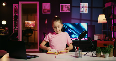 Kid entertainer presenting Bluetooth wireless headphones from brand sponsoring video, urging viewers to buy it. Happy girl does influencer marketing by advertising audio products to subscribersの写真素材