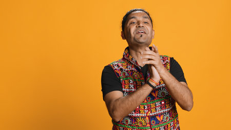 Joyful indian man happily clapping hands, ecstatic about accomplishments. Excited person reacting to good news, cheering, applauding, isolated over studio background, camera Aの写真素材