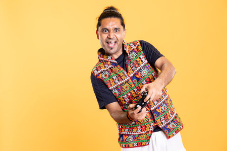 Portrait of euphoric gamer feeling rush while killing foes in videogame with motion controlled joystick. Ecstatic man pressing gamepad buttons, enjoying slaying enemies, studio backdropの写真素材