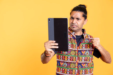 Menacing man threating to punch friend during fight on videocall. Wrathful person full of rage intimidating mate during teleconference meeting, isolated over studio backgroundの写真素材