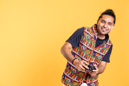 Portrait of cheerful gamer smiling, finishing videogame levels with motion controlled joystick. Delighted man pressing gamepad buttons, having fun defeating enemies, studio backdropの写真素材