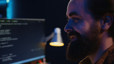 Joyous remotely working programmer in home office doing coding on computer at desk. Upbeat...
