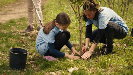 Diverse volunteers team planting trees seeds in the forest, digging holes to preserve natural habitat and cultivate life after. People fighting ecological justice, environmental care. Camera A.の写真素材