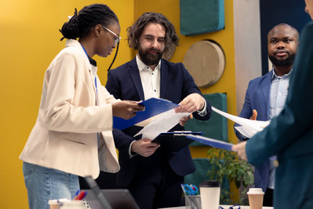 Team of business colleagues study feedback on old projects to improve their work for the future, developing marketing strategies in coworking space meeting room. Startup organization activity.の写真素材