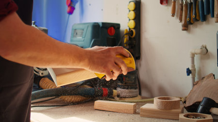 Manufacturer working in joinery using sanding block to remove imperfections on wood piece....