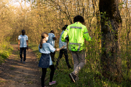 Captain of the rescue party directs his team through the forest to find details during ongoing hunt for a missing person. Voices calling for a civilians name, man lost into the wilderness.の写真素材