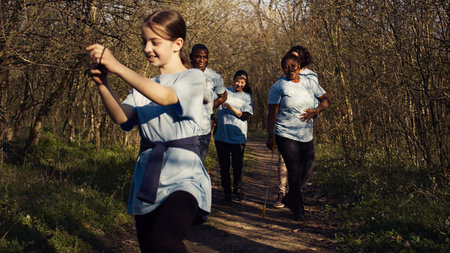 Cheerful proud group of activists finishing litter cleanup in a forest, celebrating their achievement in restoring natural environment. People smiling and enjoying their recycling success. Camera B.の写真素材