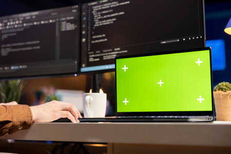 Developer working on isolated screen laptop, futureproofing company network from downtimes and unexpected system failures. Admin using chroma key notebook, increasing data security, close upの写真素材