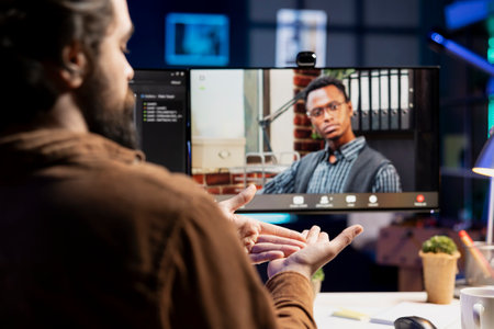 Cybersecurity professional helped by coworker during internet videocall to look for company security...
