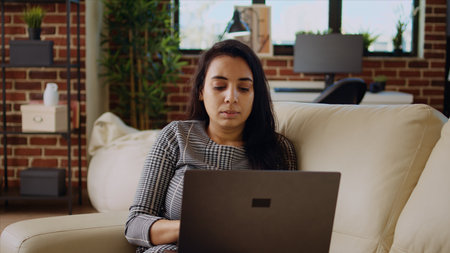 Teleworker lying on couch, remotely performing tasks in personal office. Relaxed freelancer...