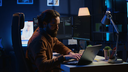 Computer scientist putting headphones on while developing code on PC, making time pass faster during remote job shift. IT admin doing multitasking in home office while listening music, camera Aの写真素材