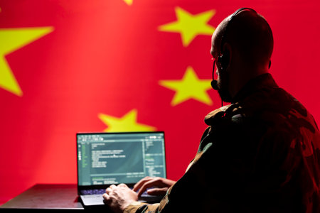 Chinese army telecommunication systems operator using radio and satellite tech, talking in headphones mic. China military dispatcher managing communications networks, typing on deviceの写真素材