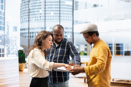 Professional team participates in an office tour with a real estate agent, focusing on architectural blueprints, property layout and investment planning. Realtor evaluating modern office space.の写真素材