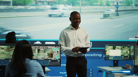 Team leader supervising his team in control center office to work on monitoring traffic by following...