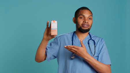 Portrait of doctor talking about importance of using high protection sunscreen products, studio backdrop. African american healthcare specialist telling people to use anti ultraviolet creams, camera Aの写真素材