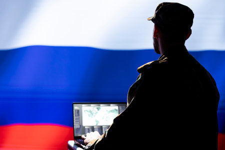 Kremlin regime russian agent combating organized crime and terrorism using detection system on laptop. Russia FSB officer protecting national sovereignty by tracking terroristsの写真素材