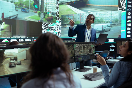 Indian team leader gives insight to his employees at shipping agency headquarters, people working on help couriers deliver their cargo in time. Operators monitoring traffic, gps tracking.の写真素材