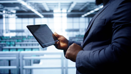 Engineer in high tech facility using tablet to patch network issues leading to slow data transfer...