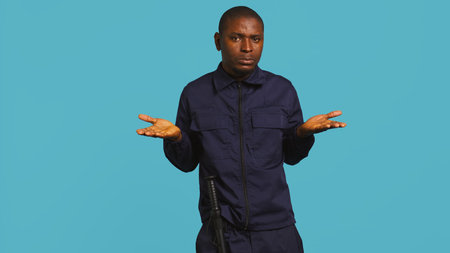 Clueless security guard shrugging shoulders, unable to answer people inquiries. Portrait of bodyguard doing lacking knowledge hand gesture, isolated over studio background, camera Bの写真素材