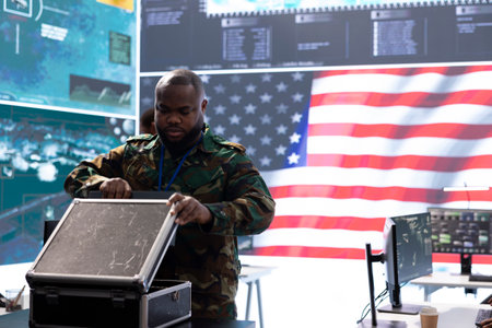 Military specialist oversees cybersecurity operations in a high tech monitoring room, protecting classified data and state secrets by supervising CCTV satellite surveillance systems.の写真素材
